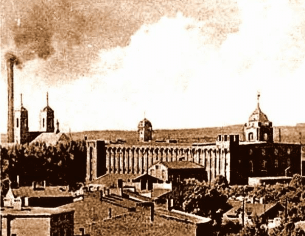 Zdjęcie przedstawia panoramę Starego Widzewa. Widzimy na nim kamienice, kościół św. Kazimierza oraz Fabrykę Nici Ariadna.