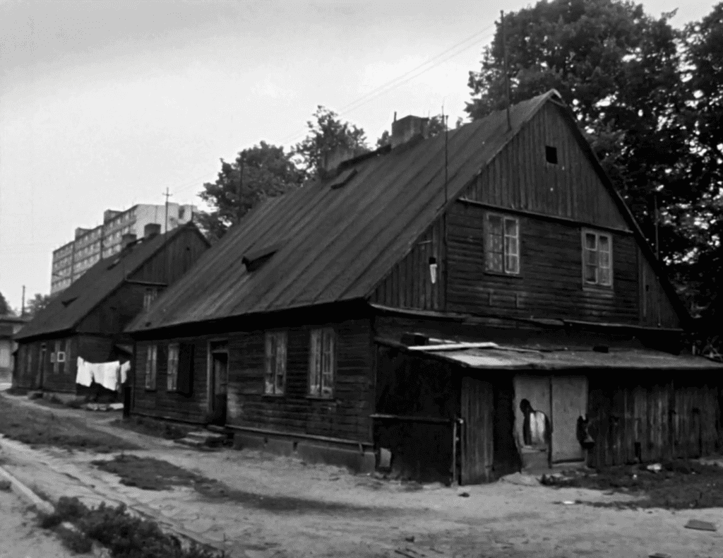 Czerno- białe zdjęcie przedstawiające szereg domków kunitzerowskich. 