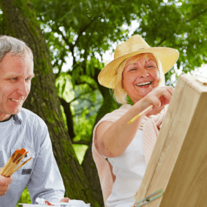 Zdjęcie przedstawia seniorów malujących podczas pleneru