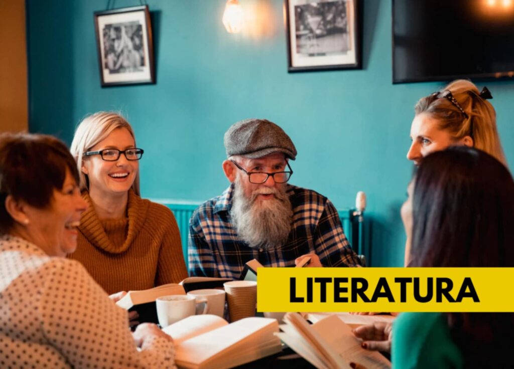 Zdjęcie przedstawia kobiety i mężczyznę w wieku dojrzałym. Osoby siedzą przy stole i czytają książki.