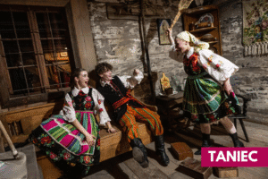 trzy osoby w kostiumach ludowych w izbie